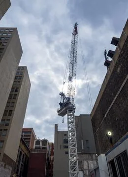 Construction Crane erected in between tall buildings Fotos de archivo