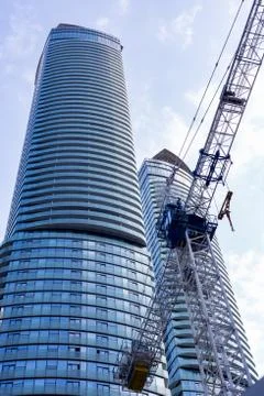 Construction crane in front of corporate skyscraper Stock Photos