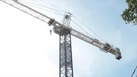 Construction crane high in sky with blue sky clouds behind Stock Footage 251354574