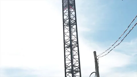 Construction crane high in sky with blue sky clouds behind, pan tilt from bottom Stock Footage 251354846