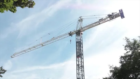 Construction crane high in sky with blue sky clouds behind, with whole top Video stock 251354958