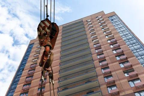 Construction crane hook with multi-storey building under construction Stock Photos