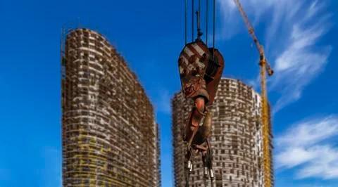Construction crane hook with multi-storey building under construction Stock Photos