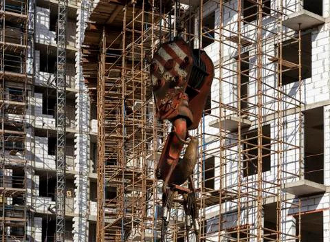 Construction crane hook with multi-storey building under construction Foto stock