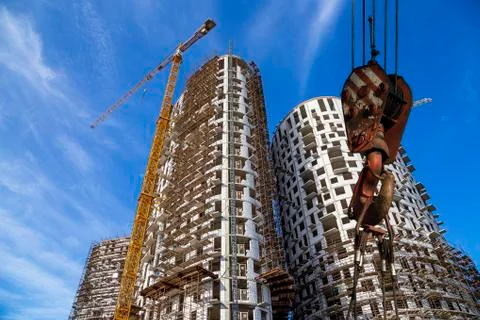 Construction crane hook with multi-storey building under construction Stock Photos