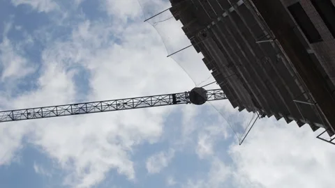 Construction Crane Lifting Concrete Bucket at Building Site Stock Footage 313757994