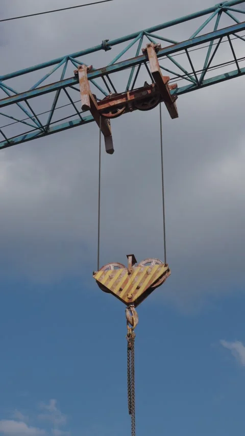 Construction crane lifting a concrete bucket at an active building site. Stock Footage 326794325