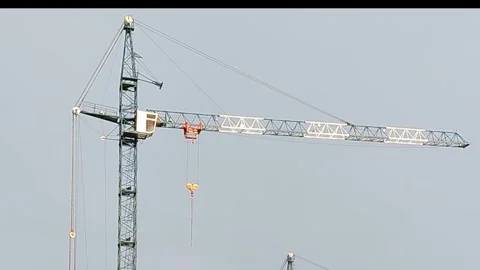 Construction crane lifting materials at a building site, showcasing the operator Stock Footage 331984147