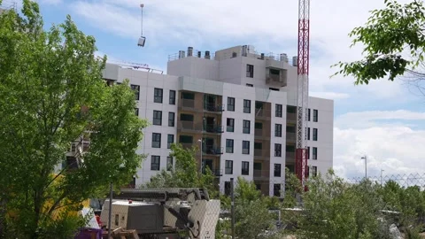 Construction crane lifting materials at residential building Stock Footage 334736681