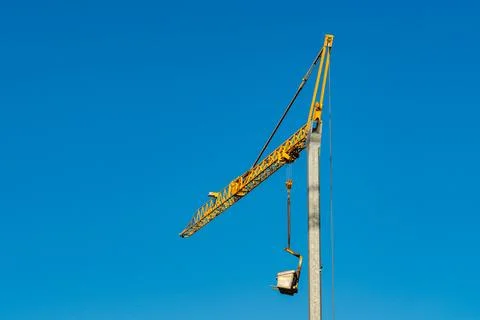 Construction crane lifting materials under clear sky Stock Photos