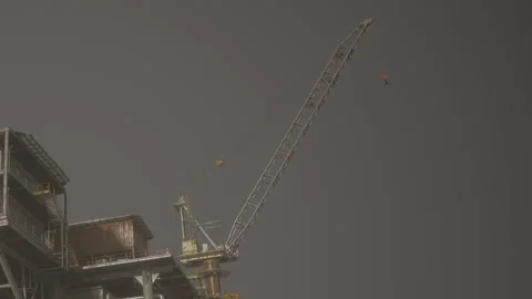 Construction crane is lifting materials at a work site in the evening Stock Footage 342803533