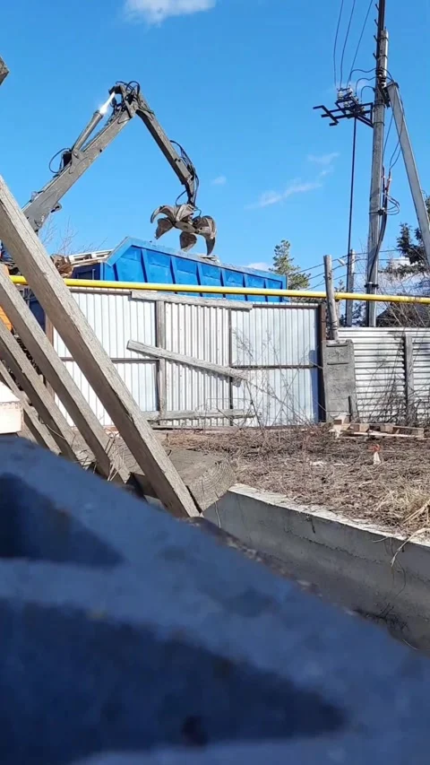 Construction crane lifting wooden pallets in outdoor industrial area Stock Footage 331572463
