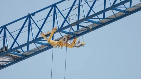 Construction crane lifts heavy loads at a building site in the city during Stock Footage 338246152