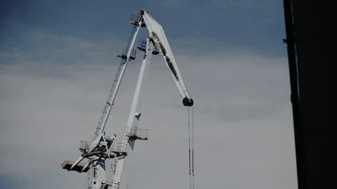 Construction crane lifts the load against the gray sky Stock Footage 105840497
