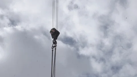 Construction crane lowers hook with chains Stock Footage 106628194