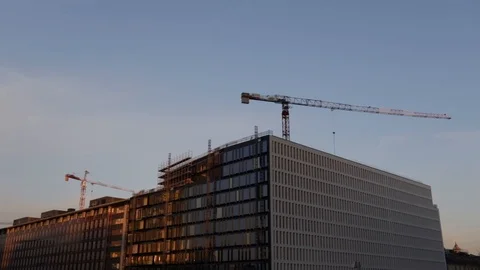Construction crane makes a complete revolution over a large palace Stock Footage 103340540