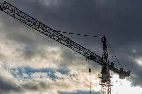 A construction crane with many clouds in the background Stock Photos