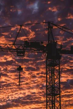 Construction crane in the middle of an amazing sunset Stock Photos