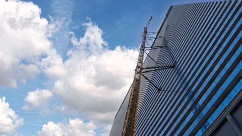 Construction crane moving along skyscraper facade timelapse Stock Footage 337298304