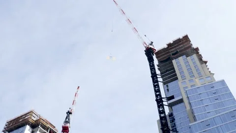 Construction crane moving a heavy building object. 動画素材 151488682