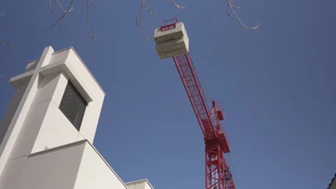Construction crane operating near a modern church building Stock Footage 329934896