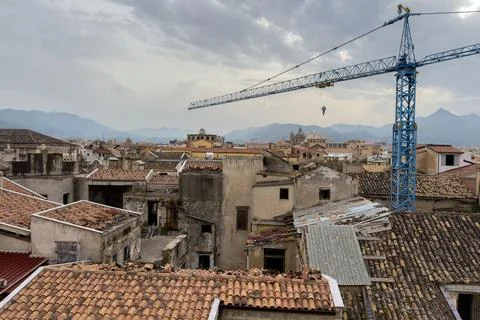Construction crane over historic rooftops. Photos