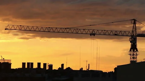 Construction crane in realtime action over a city skyline silhouette Stock Footage 41337837