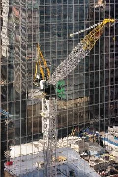 Construction crane reflected in glass skyscraper in New York USA Stock Photos