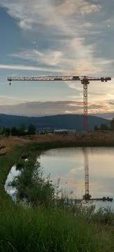 Construction crane reflected off the lake Stock Photos