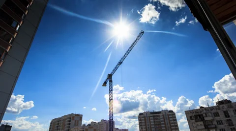 Construction crane rotating over city buildings and blue sky background. Timelap Stock Footage 27671750