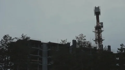 Construction crane silhoette. Construction of a tall building at forest. Video stock 104624162