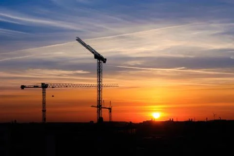 The construction crane in silhouette during sunrise Stock Photos