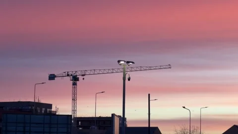 Construction crane silhouette under vibrant sunset 4K Stock Footage 330948107