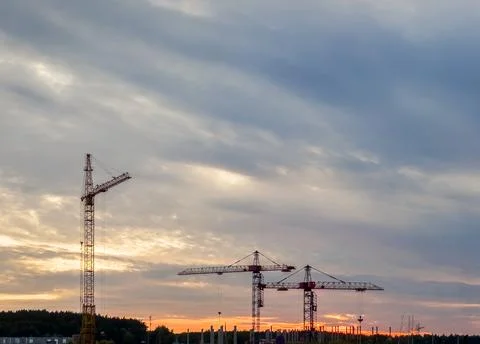 Construction crane in sky, evening time, building process Stock Photos