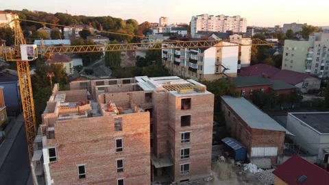 A construction crane stands above the structure of the house Stock Footage 163052611