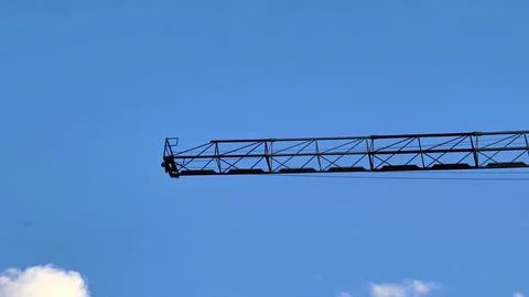 A construction crane stands against the bright blue sky, showcasing industr.. Foto stock