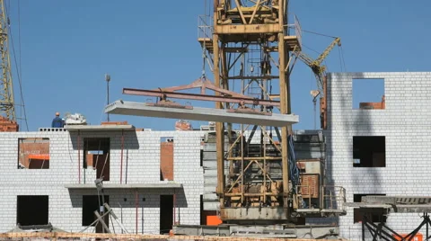 Construction crane supplying slabs for builders Stock Footage 65884430