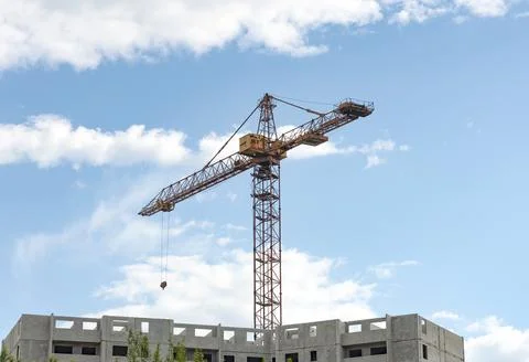 Construction crane tower against a blue sky. Stock Photos