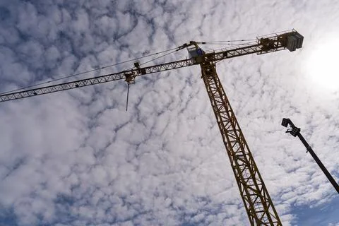 Construction crane towering against altocumulus clouds in batumi Stock Photos