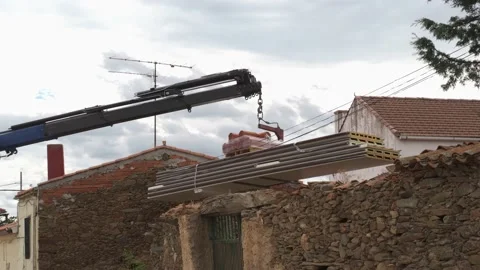 Construction crane transporting material for the construction of a house. Stock Footage 166831067