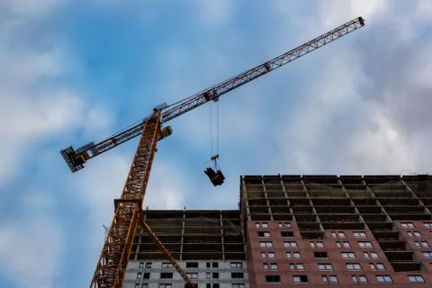 Construction crane is working on the construction of a multi-storey building Stock Photos