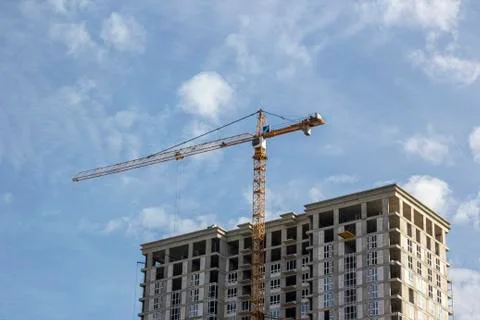 Construction crane is working on the construction of a multi-storey building Stock Photos