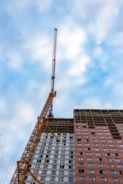 Construction crane is working on the construction of a multi-storey building Stock Photos