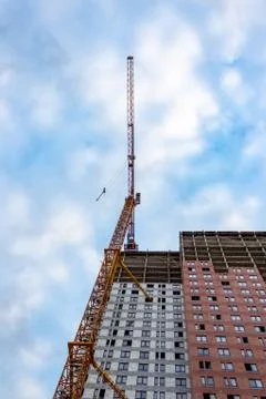 Construction crane is working on the construction of a multi-storey building Stock Photos