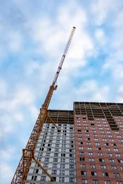 Construction crane is working on the construction of a multi-storey building Stock Photos