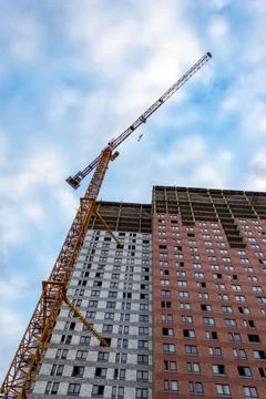 Construction crane is working on the construction of a multi-storey building Stock Photos