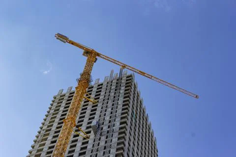 Construction crane is working on the construction of a multi-storey building Stock Photos