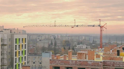 A construction crane is working on a construction site. Construction at sunset. Stock Footage 229547008