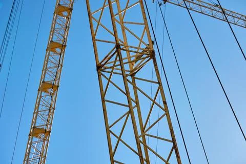 Construction crane working high above a city skyline during a clear day 写真素材