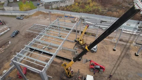 Construction crane works on the construction of a framed iron roof Video stock 172129313